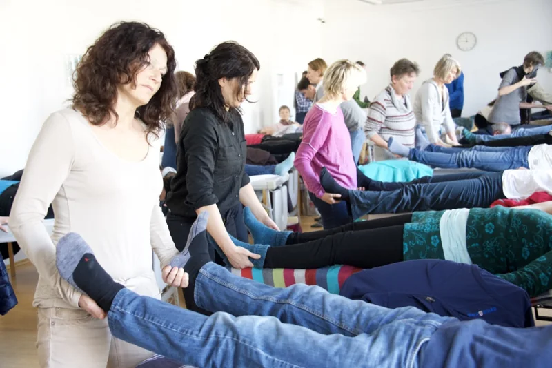 Workshop-Situation: Teilnehmer:innen üben in Reihen an Behandlungsbänken